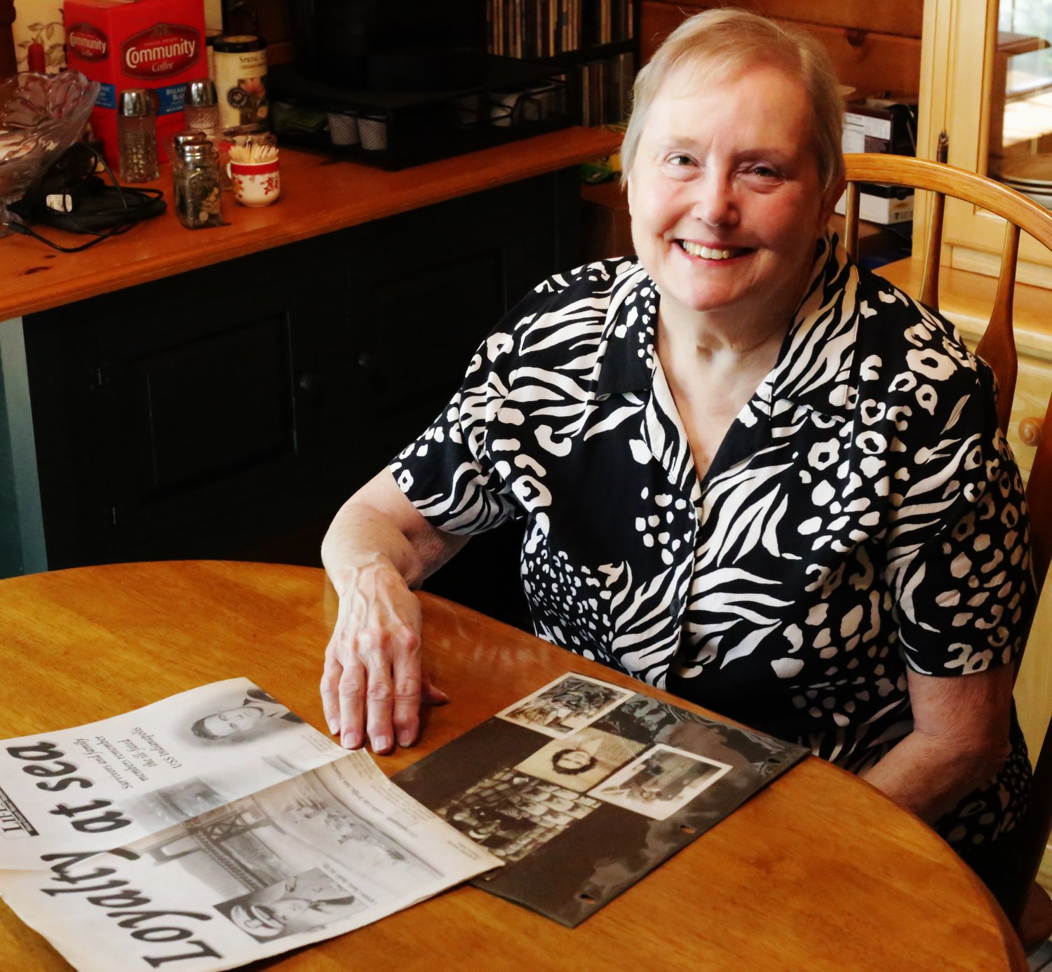 Lebow’s daughter, Mineola resident Sonja Rosson, shares some memorabilia about her family’s story. (Monitor photo by John Arbter)